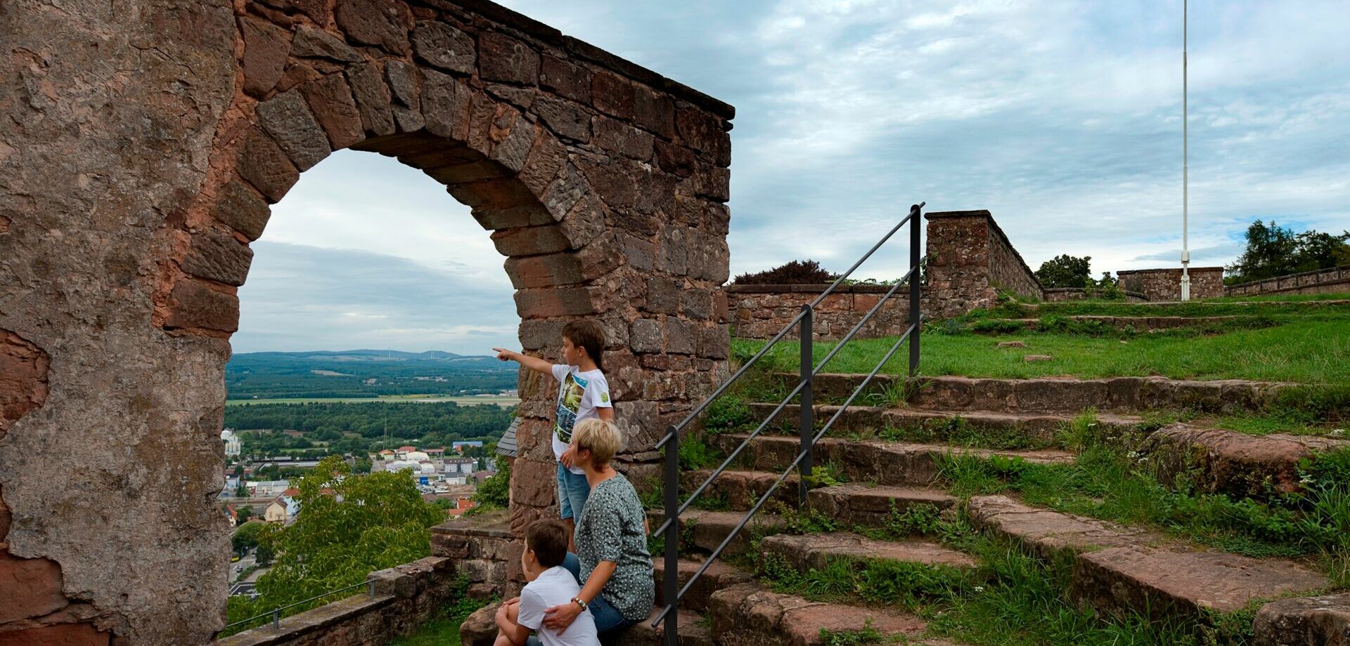 Familie weit oben auf Burg Nanstein in die Ferne auf Landstuhl blickend